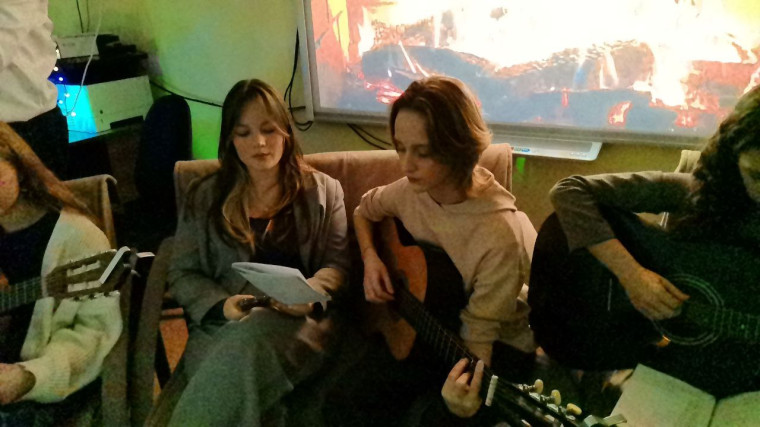 Фото праздничных посиделок. На полу в центре комнаты светятся лампочки в форме сердечка..